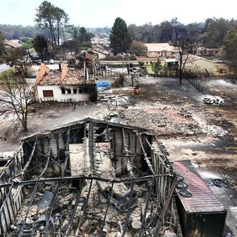 A drone view shows burnt building in an area affected by wildfire, in Le Porge