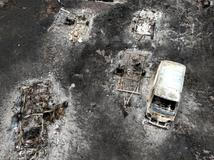A drone view shows a burnt vehicle in an area affected by wildfire, in Le Porge