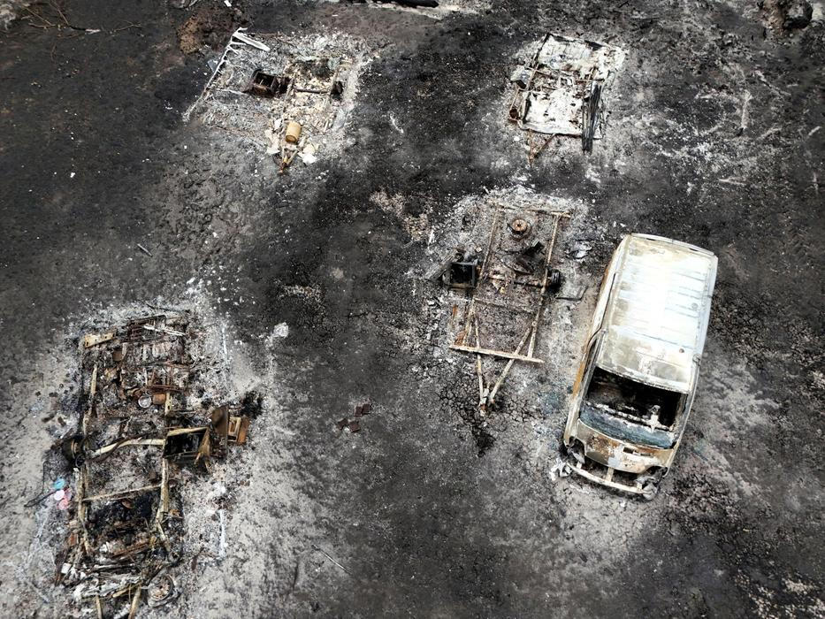A drone view shows a burnt vehicle in an area affected by wildfire, in Le Porge