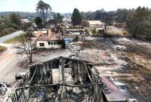 A drone view shows burnt building in an area affected by wildfire, in Le Porge