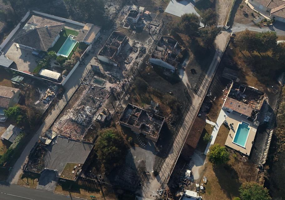 A drone view shows burnt buildings in an area affected by a wildfire in Le Porge