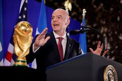 Gianni Infantino stojí vedle trofeje pro mistry světa ve fotbale během recepce FIFA v newyorské Trump Tower