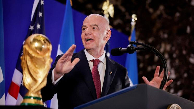 Gianni Infantino stojí vedle trofeje pro mistry světa ve fotbale během recepce FIFA v newyorské Trump Tower