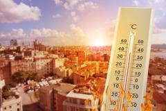 Thermometer,Showing,High,Temperature,Against,City,During,Hot,Day