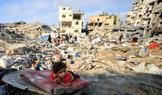 A Palestinian girl child lies on a damaged mattress at the site of Wednesday's Israeli strike on a house whose residents were pre-warned by the Israeli military to evacuate, in Gaza City