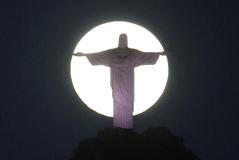 The moon shines behind the Christ the Redeemer statue in Rio de Janeiro,