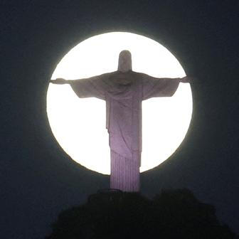The moon shines behind the Christ the Redeemer statue in Rio de Janeiro,