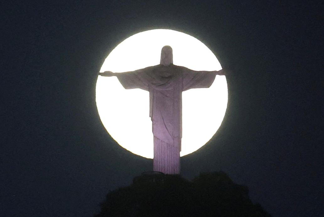 The moon shines behind the Christ the Redeemer statue in Rio de Janeiro,