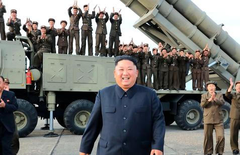 Severokorejský vůdce Kim Čong-un sleduje test nově vyvinutého vícenásobného raketometu na neznámém místě. Státní média uvedla, že zkoušku osobně řídil v srpnu 2019.