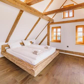 V patře je stylový pokoj s výhledem do krajiny a volně stojící vanou. Součástí je kuchyňský kout.