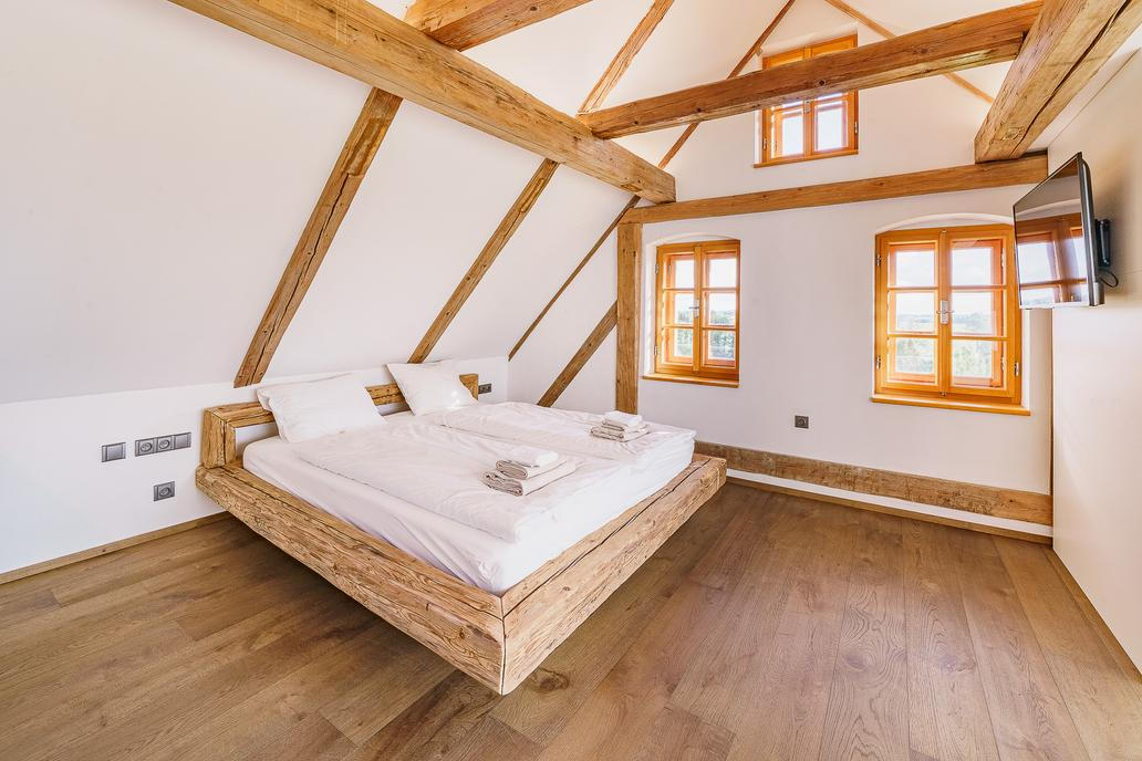 V patře je stylový pokoj s výhledem do krajiny a volně stojící vanou. Součástí je kuchyňský kout.
