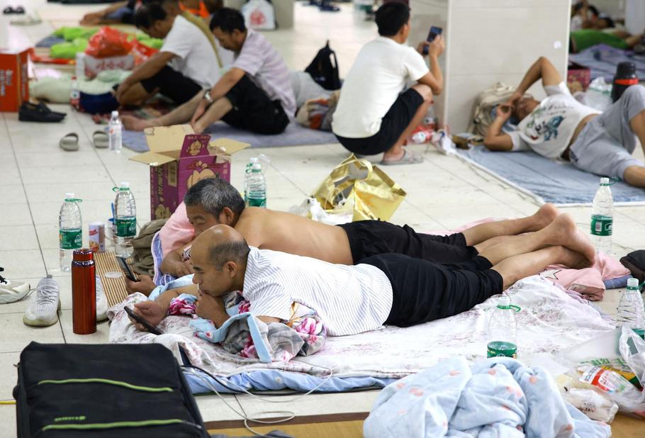 Residents rest after being relocated to a middle school turned into a shelter as Typhoon Dolphin approaches, in Zhejiang