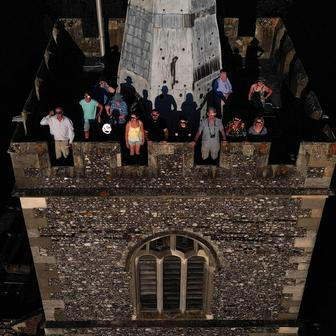 People wear special protective glasses to observe a partial solar eclipse at the top of St Mary’s Church bell tower in Rickmansworth