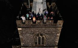 People wear special protective glasses to observe a partial solar eclipse at the top of St Mary’s Church bell tower in Rickmansworth