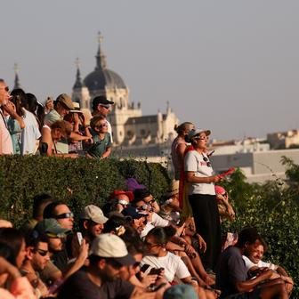 People observe a partial solar eclipse in Madrid