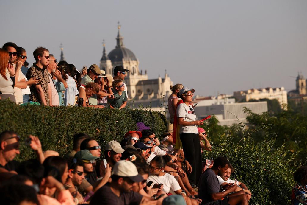 People observe a partial solar eclipse in Madrid