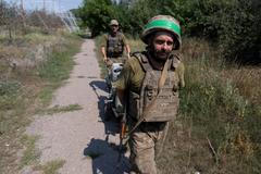 Ukrainian servicemen carry their staff along a street in the frontline town of Druzhkivka