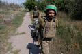 Ukrainian servicemen carry their staff along a street in the frontline town of Druzhkivka