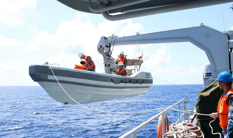 A search boat carrying rescue workers is set down from Mianyang warship on the waters suspected to be the site of the missing Beijing-bound Malaysia Airlines flight MH370