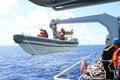 A search boat carrying rescue workers is set down from Mianyang warship on the waters suspected to be the site of the missing Beijing-bound Malaysia Airlines flight MH370