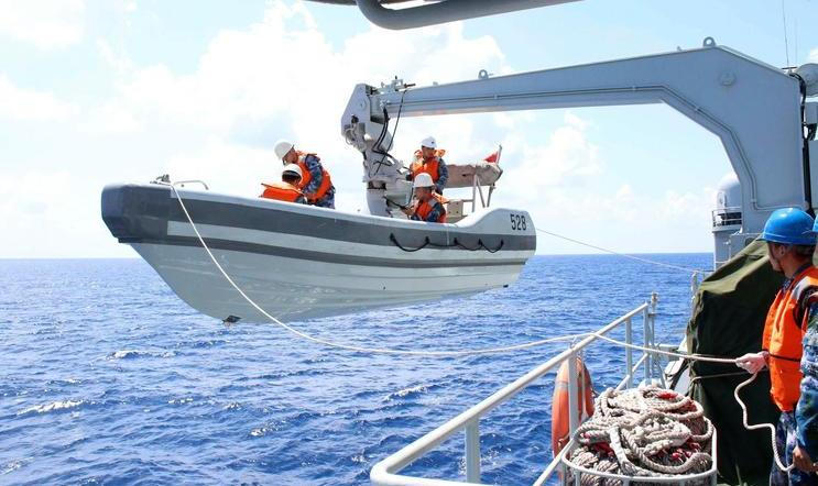 A search boat carrying rescue workers is set down from Mianyang warship on the waters suspected to be the site of the missing Beijing-bound Malaysia Airlines flight MH370