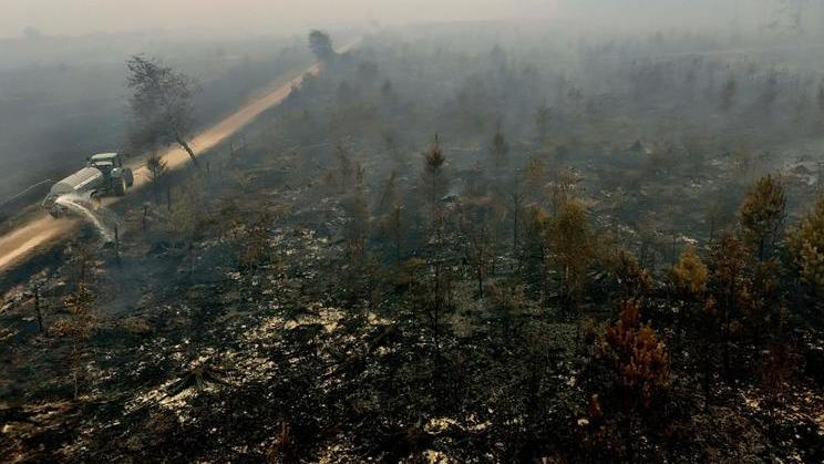 V neděli nadále hořelo několik ohnisek požáru, přičemž vítr pravidelně měnil směr. Na snímku je část spálené krajiny.
