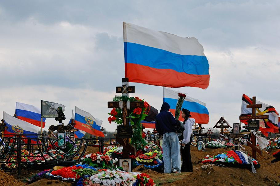 People visit the grave of a Russian service member in Donetsk