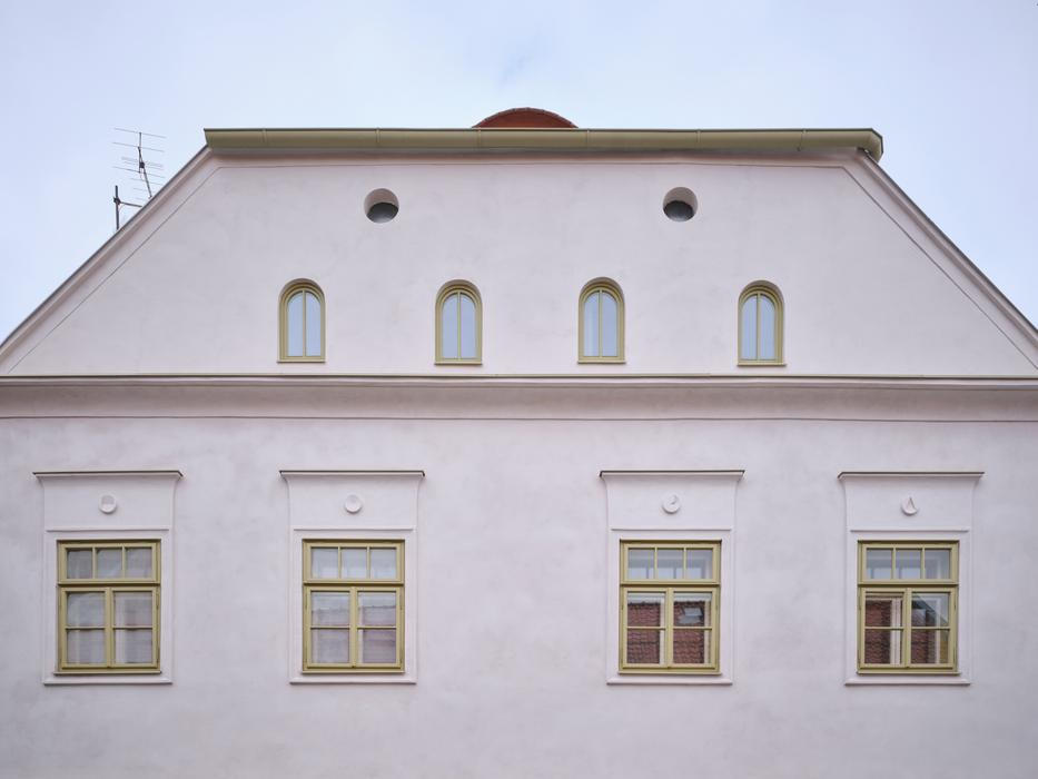 Podařilo se najít fragment fasády na jedné z fotografií, kde je patrné, že nad okny v patře byly výrazné suprafenestry a dům měl výraznou římsu.