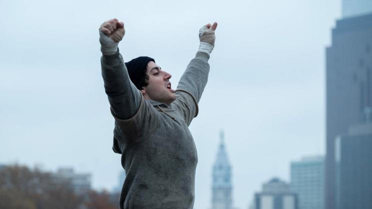 Anthony Ippolito jako herec Sylvester Stallone ve filmu Já, Rocky (2026). Vítězné gesto s rukama nad hlavou se stalo ikonickým.