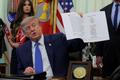 U.S. President Donald Trump signs an executive order in the Oval Office at the White House in Washington