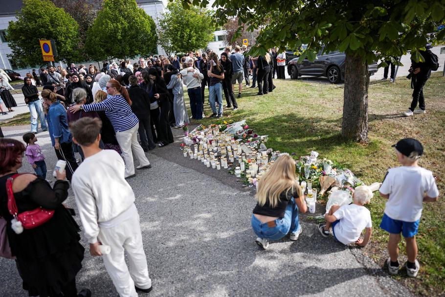 Residents leave flowers and candles at a makeshift memorial outside a shool the day after a sword attack, in Fagersta