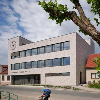 Protože stavební parcela nabízela omezené prostorové možnosti, má škola kompaktní vertikální uspořádání. Tři podlaží propojuje centrální dvorana, kolem níž jsou organizovány jednotlivé učebny, kabinety pedagogů, sborovna i administrativní zázemí.