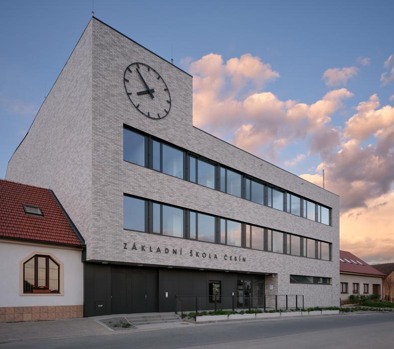 Význam stavby jako jedné z klíčových veřejných budov v obci podtrhují hodiny umístěné na hlavním průčelí, které se díky poloze stavby stávají novou orientační dominantou návsi i příjezdu do obce.