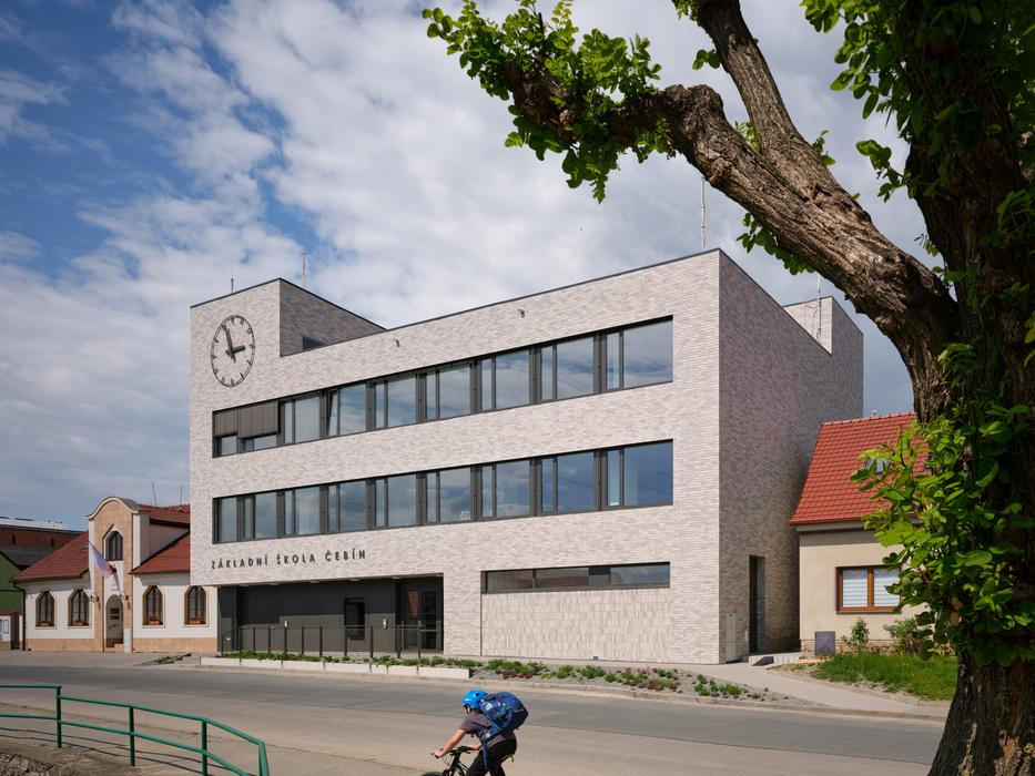 Protože stavební parcela nabízela omezené prostorové možnosti, má škola kompaktní vertikální uspořádání. Tři podlaží propojuje centrální dvorana, kolem níž jsou organizovány jednotlivé učebny, kabinety pedagogů, sborovna i administrativní zázemí.