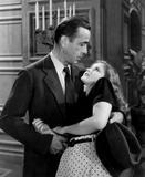 Generálova zhýralá dcera Carmen (Martha Vickersová) se pokusí stojícímu Marlowovi (Humphrey Bogart) sednout do klína.