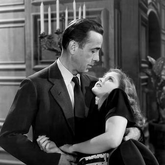 Generálova zhýralá dcera Carmen (Martha Vickersová) se pokusí stojícímu Marlowovi (Humphrey Bogart) sednout do klína.