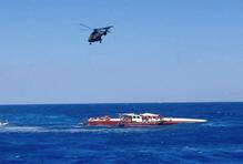 A helicopter flies during a rescue operation after a ferry that capsized off the coast of Northern Cyprus