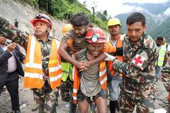 A man who survived is carried by members of a search and rescue team after being rescued from inside a tunnel at the Trishuli-3A Hydropower Project following devastating floods and mudslides that struck the Bhotekoshi River