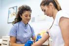 ["Medical technologist doing a blood draw services for patient. lab assistant with sterile rubber gloves taking blood sample from patient."]