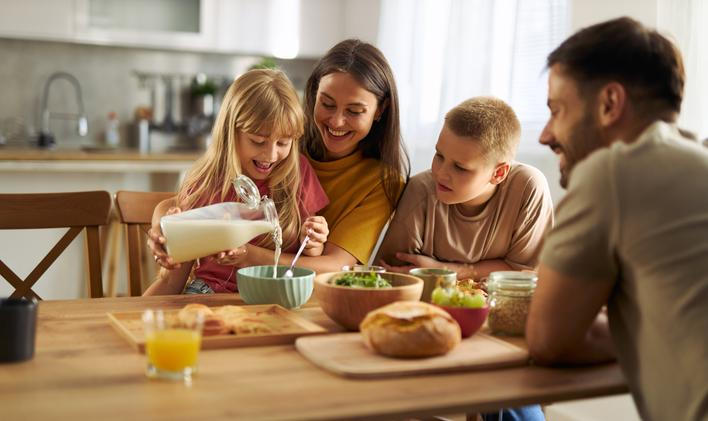 Happy,Little,Girl,Pouring,Milk,Into,Bowl,Of,Cereals,While