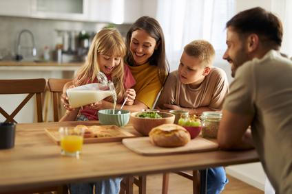 Happy,Little,Girl,Pouring,Milk,Into,Bowl,Of,Cereals,While