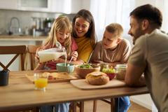 Happy,Little,Girl,Pouring,Milk,Into,Bowl,Of,Cereals,While