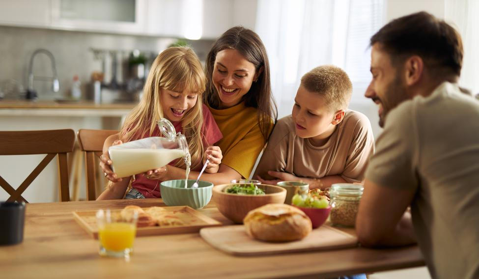 Happy,Little,Girl,Pouring,Milk,Into,Bowl,Of,Cereals,While