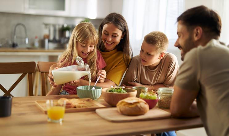 Happy,Little,Girl,Pouring,Milk,Into,Bowl,Of,Cereals,While