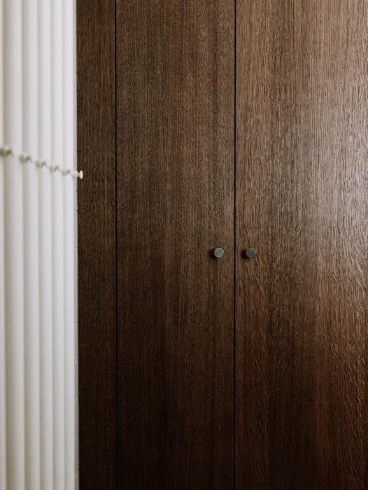 „Vestavěný nábytek z mořeného i přírodního dubu doplňují jemnější tóny materiálů, kombinace rastrů obkladů pak do interiéru vnáší nenápadnou dynamiku. Zachován zůstal tradiční design nově vyrobených špaletových oken a původní dveře,“ dodává autorka návrhu Anna Koukolová.í
