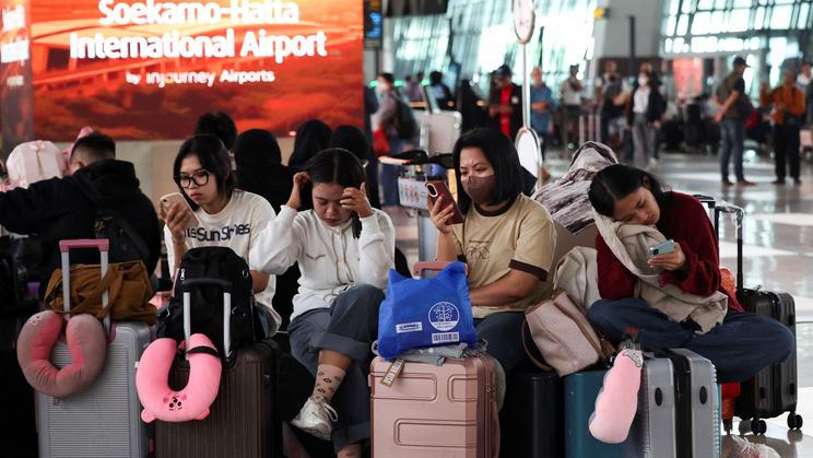 Stranded passengers wait at terminal as Soekarno Hatta International Airport closed its operations due to the eruption of the Mount Anak Krakatau volcano, in Tangerang