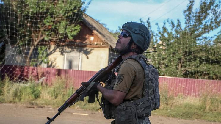 Ukrainian serviceman observes the sky for Russian drones in the frontline town of Druzhkivka