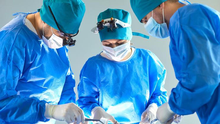 Team,Of,Professional,Doctors,Surgeons,Wearing,Blue,Medical,Uniform,Performing