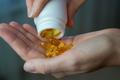 Close-up,Of,A,Woman,Pouring,Vitamin,D,Or,Omega-3,Into