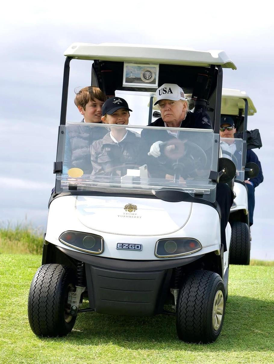 Trump za volant golfového vozíku rád usedá sám.
